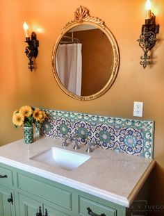 a bathroom sink sitting under a mirror next to a wall mounted faucet with lights on it