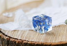 A beautiful geometric cube, filled with real forget me not flowers... each flower has been preserved and sealed so it holds its beautiful colour and remains perfectly blue-blue. We use specially formulated UV stable resin - it is crystal clear and shows how utterly beautifully blue the flowers really are. The cube is 20mm across, with a sterling silver bail, which travels the length of the cube, and comes on an 18" sterling silver chain. Longer chains are available here, if you wear your necklac Blue Square Necklace For Gift, Blue Square Necklace For Gifts, Blue Square Necklace Perfect For Gifts, Forget Me Not Flowers, Cube Necklace, Necklace Resin, Forget Me Nots, Geometric Necklace, Resin Necklace