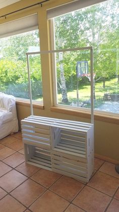 an empty room with a basketball hoop in the window and a bed on the other side