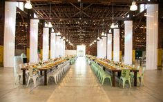 a long table set up in the middle of a large room with columns and lights