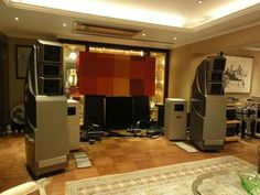 a living room filled with lots of electronics on top of a hard wood flooring