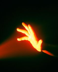 a person's hand reaching out towards the light