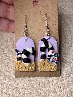 a pair of earrings that are on top of a piece of cardboard with an image of a cow