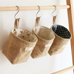 three cups hanging from a wooden rack on a wall