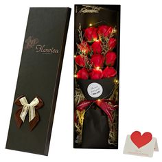 a black box with red roses in it next to a valentine's day card