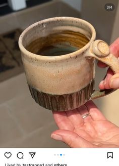 someone is holding a cup that has been made out of clay with a spoon in it