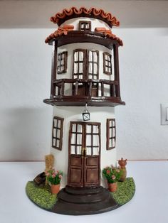 a white and brown doll house with two stories on the front, one story above the other