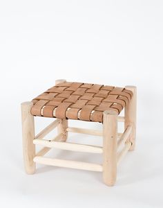 a wooden stool made out of wood with woven seat padding on the top and bottom