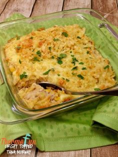 a casserole dish with meat and vegetables in it on a green napkin next to a spoon