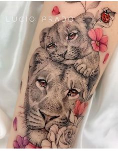 a tattoo with two lions and flowers on it