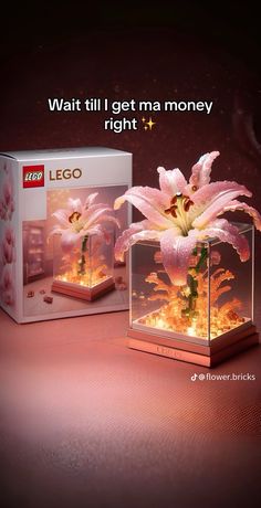 a pink flower in a glass box with the words lego written on it and an image of flowers inside