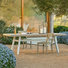 a table with two chairs and an umbrella on it in the middle of a garden