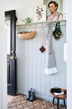 there is a coat rack and shoes hanging on the wall in this entryway area