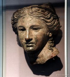 an ancient statue of a woman's head on display