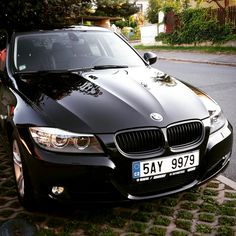 a black car is parked on the side of the road