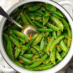 a pot filled with green beans covered in seasoning and sprinkled with orange zest