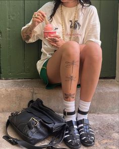 a woman sitting on the ground eating an ice cream