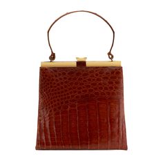 This luxurious cognac shiny alligator bag is beautifully made and features gold-color hardware & closure, and a roomy lined interior designed to carry your daily essentials.  Detailed Features 10.5 x 10 x 9.75 inches (Length x Width x Depth)  Can be carried by hand Gold-finish hardware Interior zip pocket Interior Cognac Bag, Collage Pics, Styling Accessories, My Bags, Fashion 2024, Daily Essentials, My Bag, Office Wear, Luxury Items