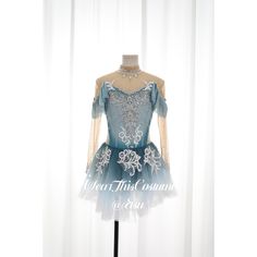 the dress is on display in front of a white curtain, and it has blue trim