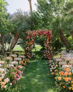 an outdoor ceremony setup with chairs and flowers on the grass, surrounded by palm trees