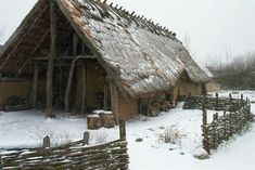 an old house with a thatched roof in the snow