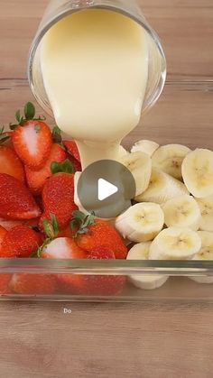 strawberries and bananas are being poured into a container