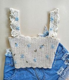 a pair of denim shorts with crochet on the bottom and an off - white top