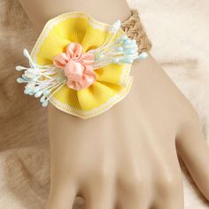 a close up of a person's hand wearing a bracelet with flowers on it