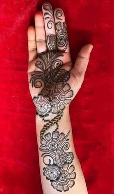 a woman's hand with henna tattoos on it