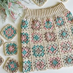 the crocheted skirt is next to several coasters and a pot holder with flowers on it