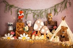 there are many stuffed animals on display in the room with flowers and lights around them