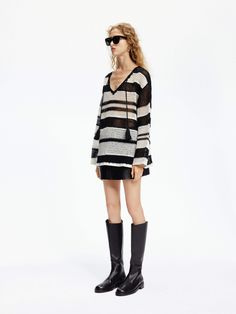 MO&Co. Women's Crochet Knit Stripe Sweater Discover the perfect blend of style and comfort with our sweater. Made from a luxurious wool blend, its crochet knit design adds a touch of transparency for an alluring look. Complete with a V-neck and tassel tie, this sweater pairs effortlessly with your favorite skirt for a chic and unique outfit. Features : - Loose crochet knit fit, sheer effect- V-neckline with tassels detail- Classic black and white stripes Code: MBD1SWT019The back length of size S