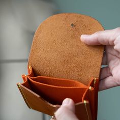 The Juno wallet is perfect for cards and cash. It has 3 sections total with the middle section being perfect for loose change. The coins won't fall out! Promise. Exterior is made from our American-made oil tanned leather in tan. Accents in peach suede. Brass button closure. Measures 4" wide by 3" high. Trifold Leather Coin Purse With Card Slots, Trifold Leather Coin Purse With Interior Card Slots, Leather Trifold Coin Purse With Interior Card Slots, Cognac Trifold Wallet With Card Slots For Everyday Use, Orange Leather Bifold Wallet, Leather Trifold Coin Purse With Card Slots, Orange Leather Wallet As Gift, Orange Wallet With Card Slots For Daily Use, Everyday Orange Leather Wallet