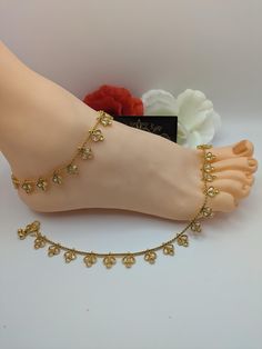 Beautiful handcrafted Indian gold plated kundan pair of anklets traditionally called payals or ghanjar. Stunning design anklets with no sound. It is a beautiful ornament worn around the ankle. You can worn it on one foot or as a pair on both feet. It is sure to make your feets look beautiful. Size: L x 26 cm / W x 1.2 cm Main Colour: Gold Stone Colour: Light Champagne  Closer: Hook clasp with bells. Package Includes: 1 pair of anklets Traditional Anklets For Diwali Party, Traditional Toe Ring Anklet As Gift, Traditional Anklets For Puja, Adjustable Traditional Anklets For Puja, Wedding Stone Work Anklets, Traditional Festive Anklets As A Gift, Wedding Anklets With Stone Work, Gold Jewelry With Gota Work For Puja, Elegant Stone Work Anklets For Festive Occasions