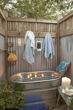 an outdoor bathtub with candles and towels