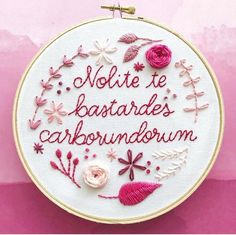 a white embroidery hoop with pink flowers and words on it