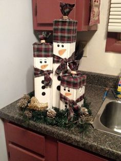 three snowmen are stacked on top of each other in front of a kitchen sink