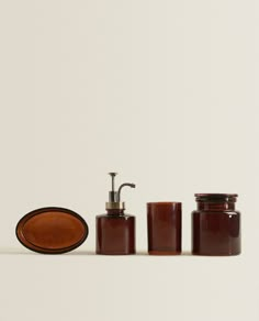 three jars with soap dispensers and a soap dish on a white surface