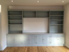 an empty room with built - in bookshelves and cabinets