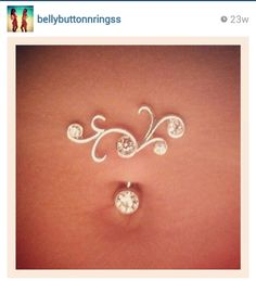 a woman's stomach with two piercings on it, one is white and the other is silver