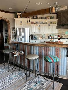 three stools are sitting at the bar in this kitchen with an area rug on the floor