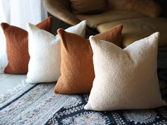 four pillows sitting on top of a rug