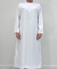 Introducing our Men's Omani Thobe, the perfect addition to your Islamic clothing collection. Made from a high-quality cotton mix fabric, this thobe is not only easy to iron but also incredibly soft and comfortable to wear. The meticulous stitching and expert embroidery make this thobe a truly stand-out piece. Available in a wide range of colours and sizes, you're sure to find the perfect fit for your personal style. And for the younger members of your family, we also offer this Omani thobe in bo White Cotton Long Sleeve Agbada, White Long Sleeve Agbada With Dabka, White Long Sleeve Agbada With Dabka Details, White Long Sleeve Thobe For Eid, Modest Long Sleeve Thobe With Dabka, White Long Sleeve Agbada For Eid, Habits Musulmans, Islamic Clothing, Mixing Fabrics