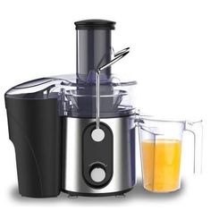 a silver and black juicer next to a glass filled with orange juice on a white background