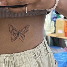 a woman's stomach with a butterfly tattoo on her belly and the bottom part of her stomach