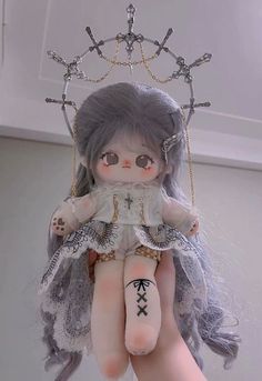 a doll with grey hair and tattoos on her arm