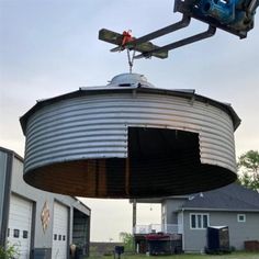 a crane is lifting a large metal tank