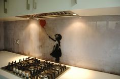 a girl with a heart balloon painting on the wall next to a gas stove top