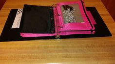 an open pink binder on top of a wooden table