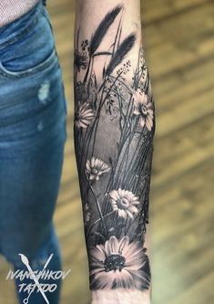 a woman's arm with flowers and grass tattoo on the left side of her body